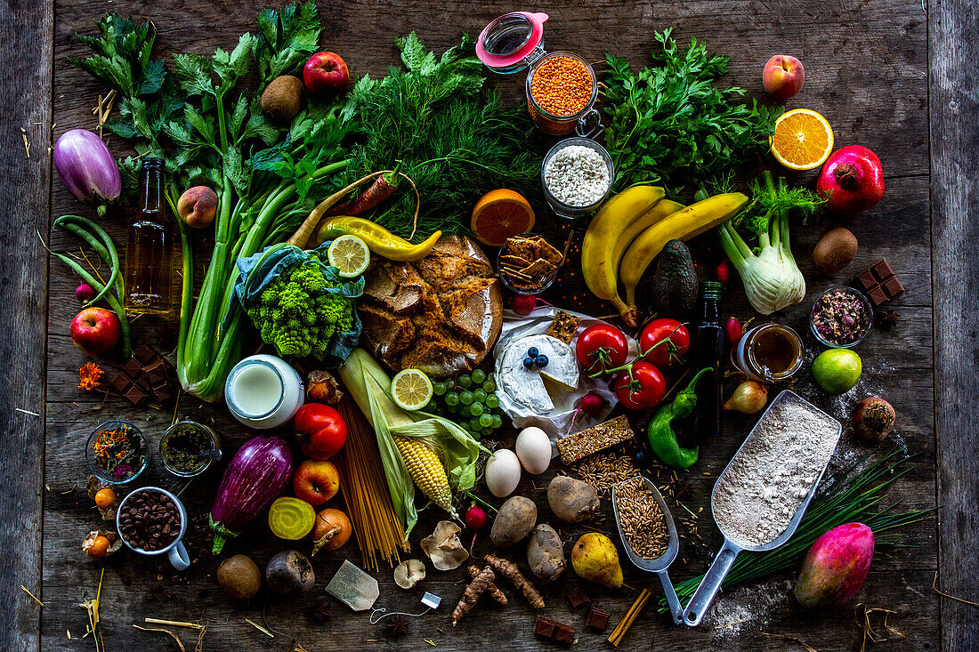 Obst, Gemüse und verschiedene Lebensmittel auf rustikalem Holztisch