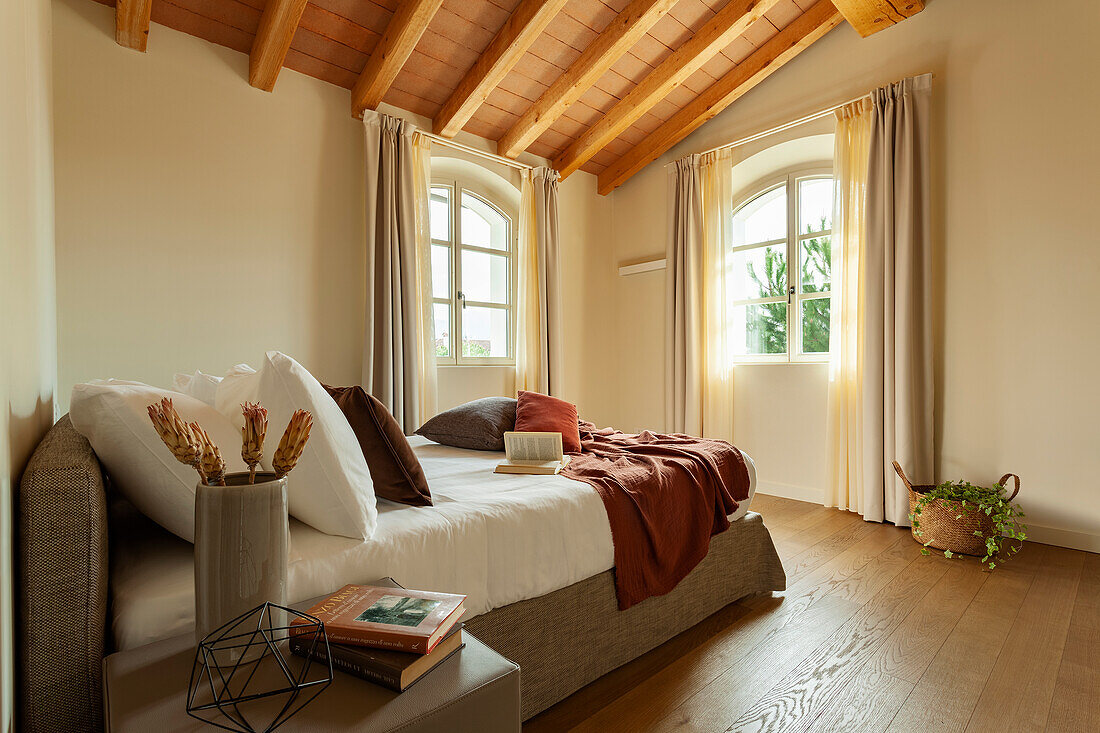 Bett mit Kissen im Schlafzimmer mit Holzdecke