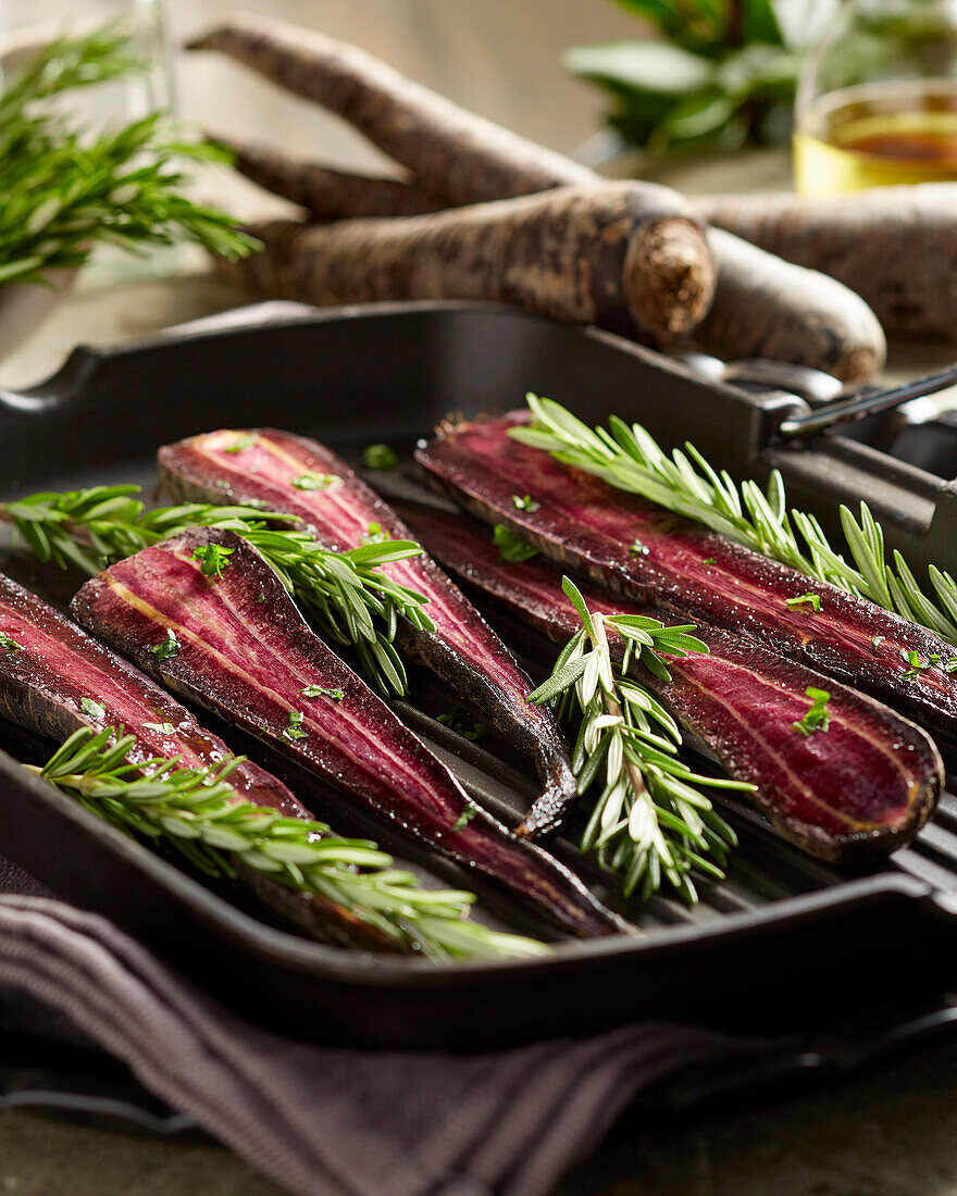 Purple carrots with rosemary in a grill pan