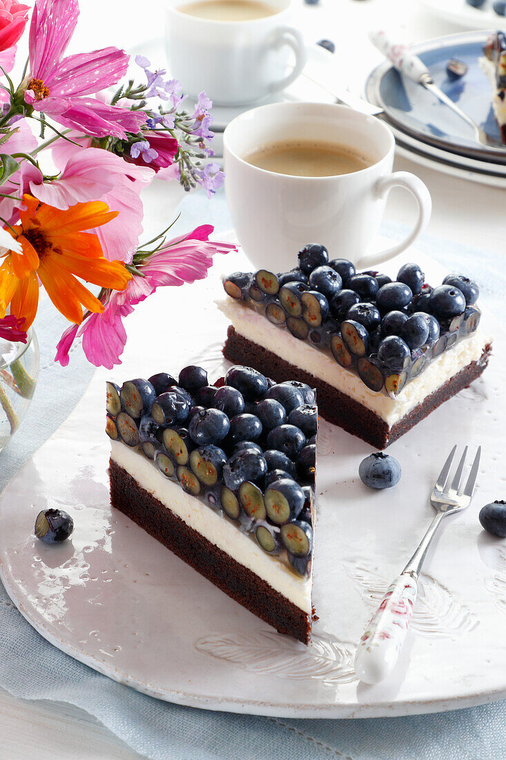Brownie cake with cream and fresh blueberries in jelly