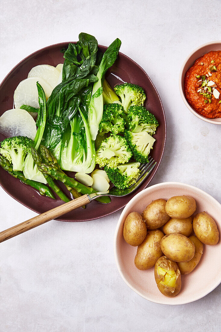 Steamed green vegetables with romesco sauce and baked potatoes