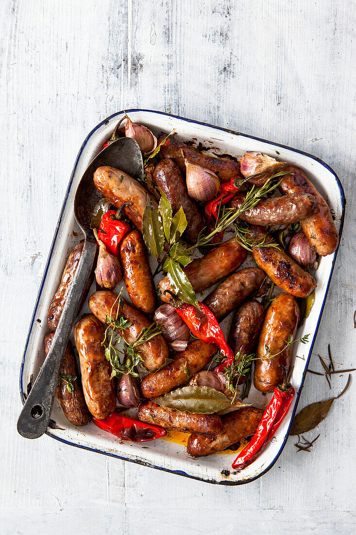 Sausages fried with garlic, thyme, rosemary, bay leaves, and red chili peppers
