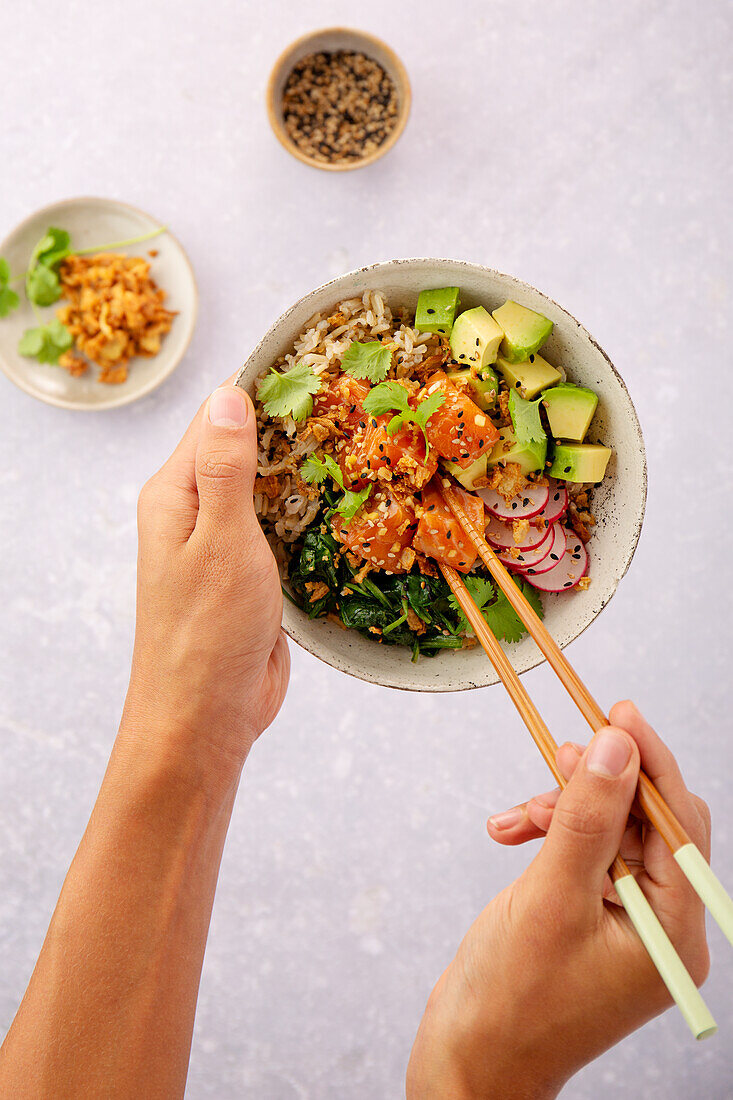 Poke bowl with salmon fillet and spinach