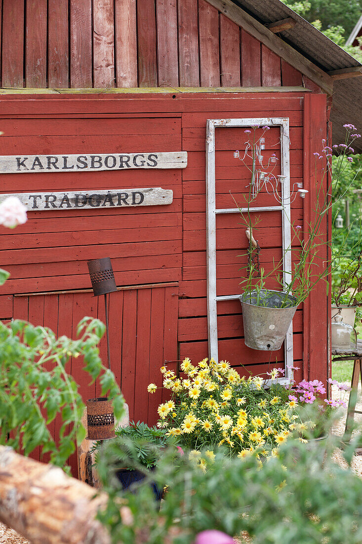 Old signs and window frames on red wooden house