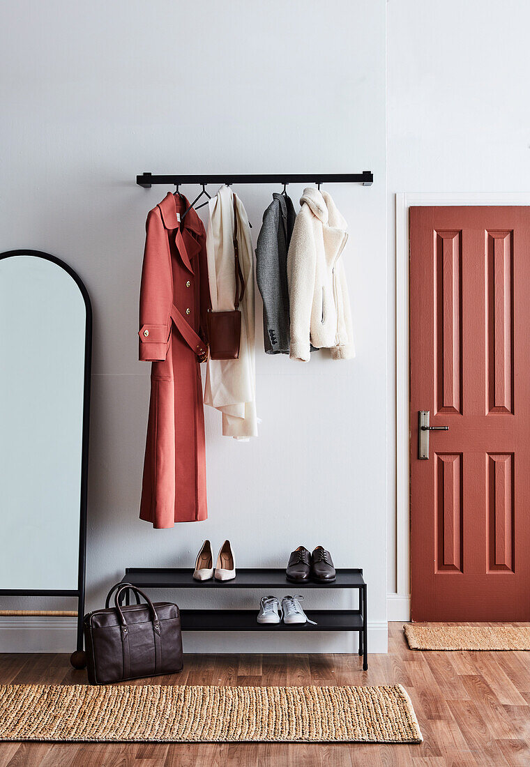 Coat rack, underneath shoe rack, and mirror in the hallway