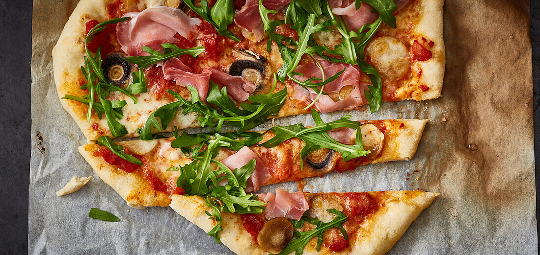 Pizza mit Pilzen, Rucola und Schinken