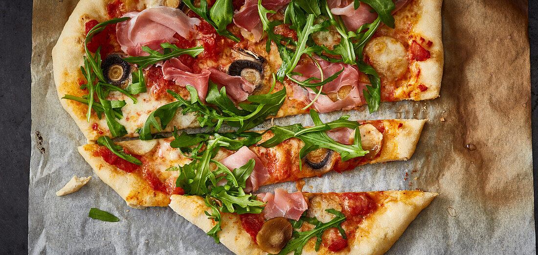 Pizza with mushrooms, rocket and ham