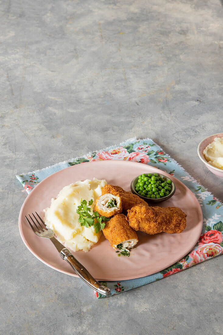 Chicken kiev with mashed potatoes and peas