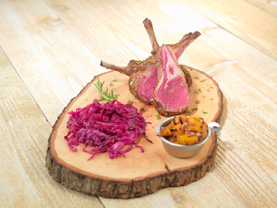 Lamb chops with red cabbage served on a rustic slice of wood