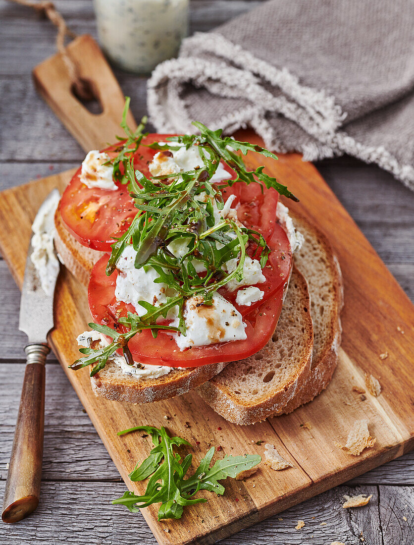 Country bread with ox heart tomatoes, cream cheese and rocket salad