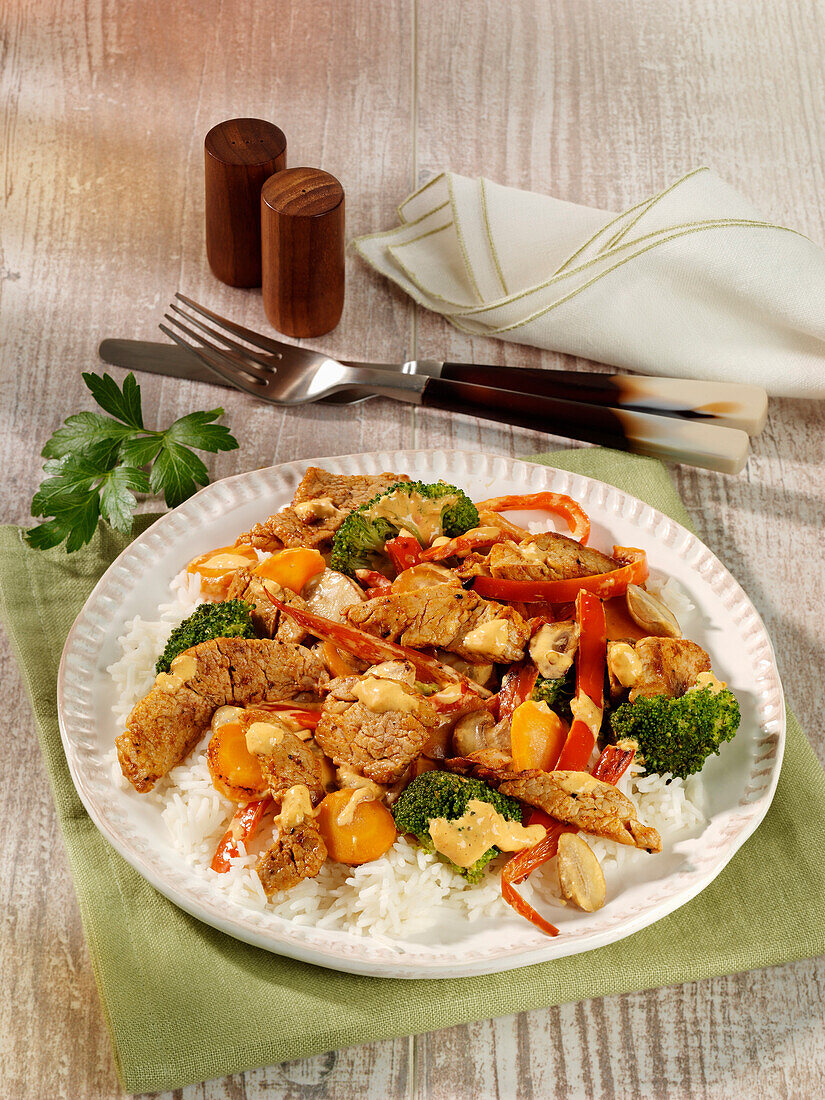 Roasted pork tenderloin tips with broccoli, peppers, and mushrooms on rice