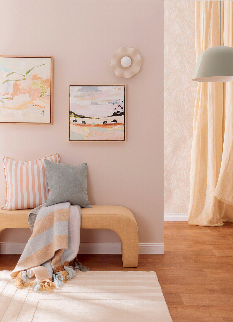 Sitzbank mit Kissen und Decke im Zimmer in Pastelltönen