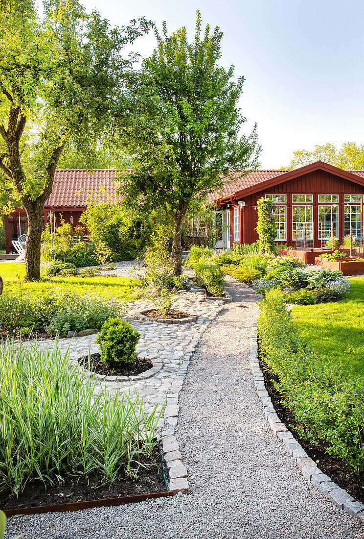 Frühlingsgarten mit Pflastersteinen und Kiesweg