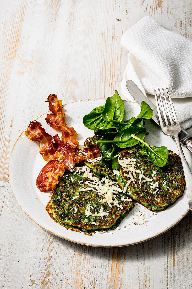 Spinach and parmesan pancakes, served with grated parmesan and crispy pancetta