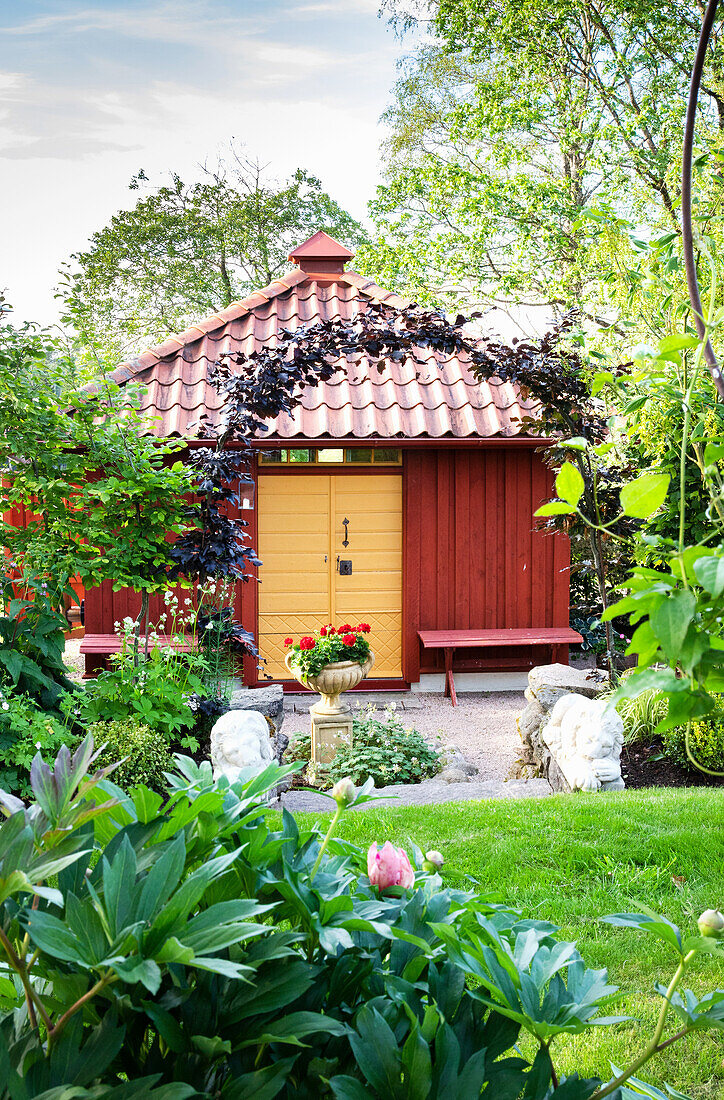 View of wooden garden pavilion, portal with copper beech tree