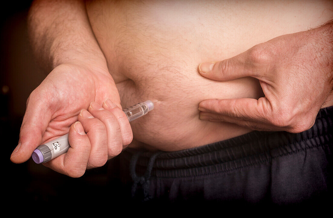 Man injecting insulin to the abdomen, conceptual image