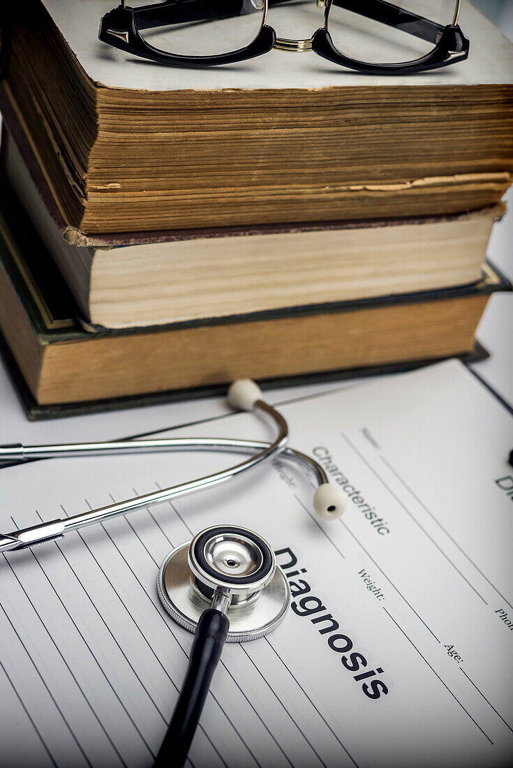 Old medical books with a stethoscope and a diagnostic form