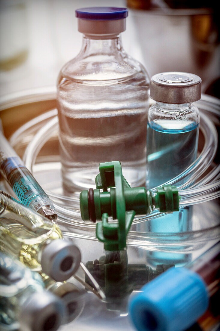 Vials and syringe in a tray metal, conceptual image