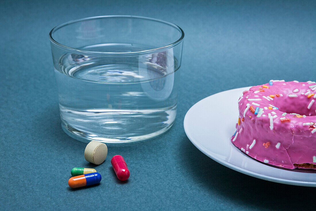 Diabetes medication next to a cake, conceptual image