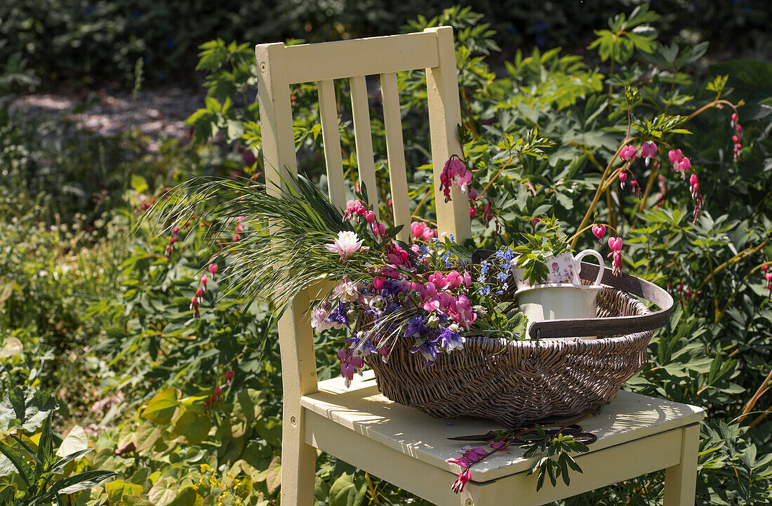 Weeping heart (Dicentra Spectabilis) and columbine (Aquilegia), flowers in wicker basket