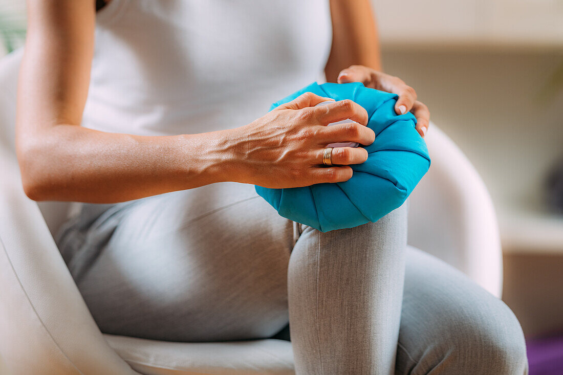 Woman holding a cold compress to her knee