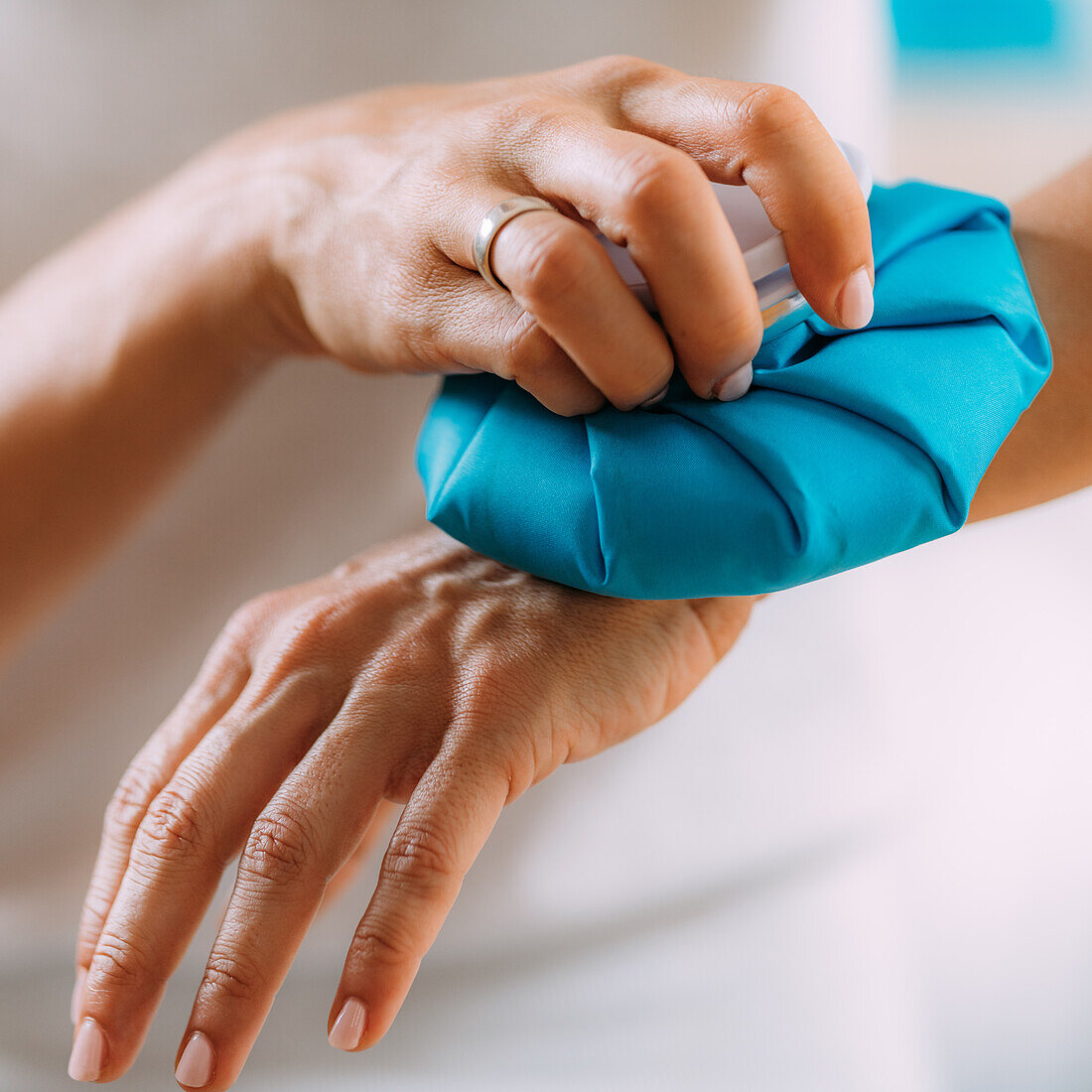 Woman holding ice bag compress on a painful wrist