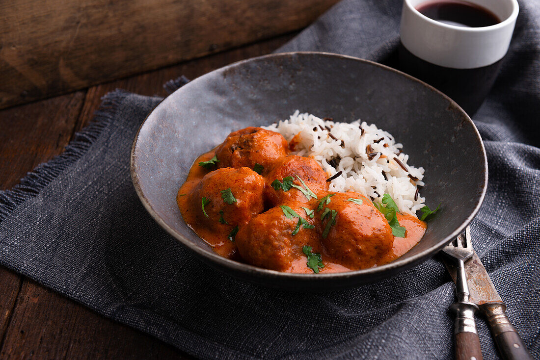 Vegan meatballs in tomato-coconut sauce with wild rice mix