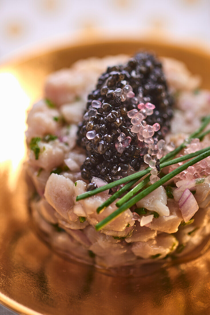 Veal tartare with caviar on a golden plate