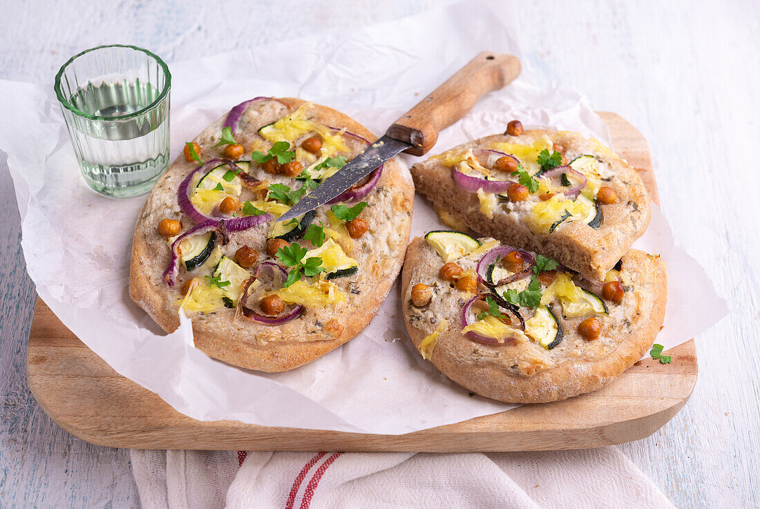 Vollkorn-Fladenbrote mit Zucchini, Kichererbsen und Zwiebeln überbacken mit veganem Käseersatz