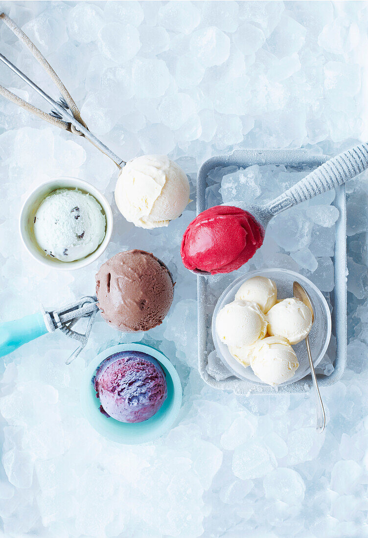 Assorted scoops of ice cream in bowls on ice cubes