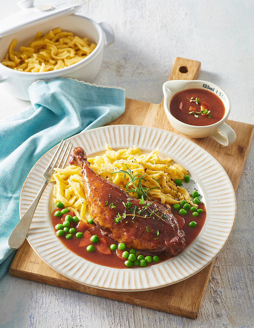 Chicken leg braised in red wine served with pasta and vegetables