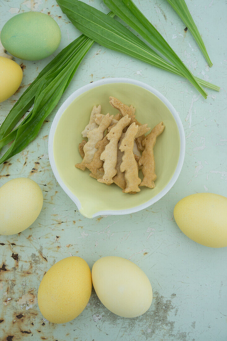 Bunny shaped cookies, colored eggs, and ribwort plantain