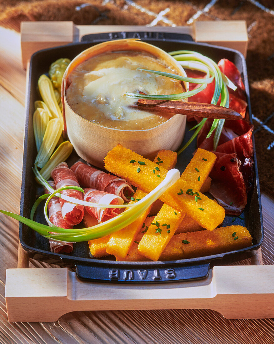 Cheese fondue with polenta sticks and ham