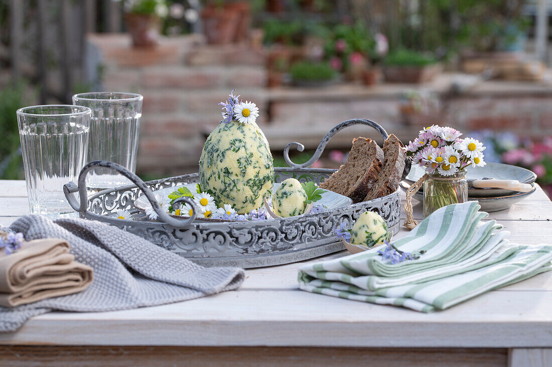 Egg-shaped herb butter with chives, parsley; garlic; thyme; decorated with daisies