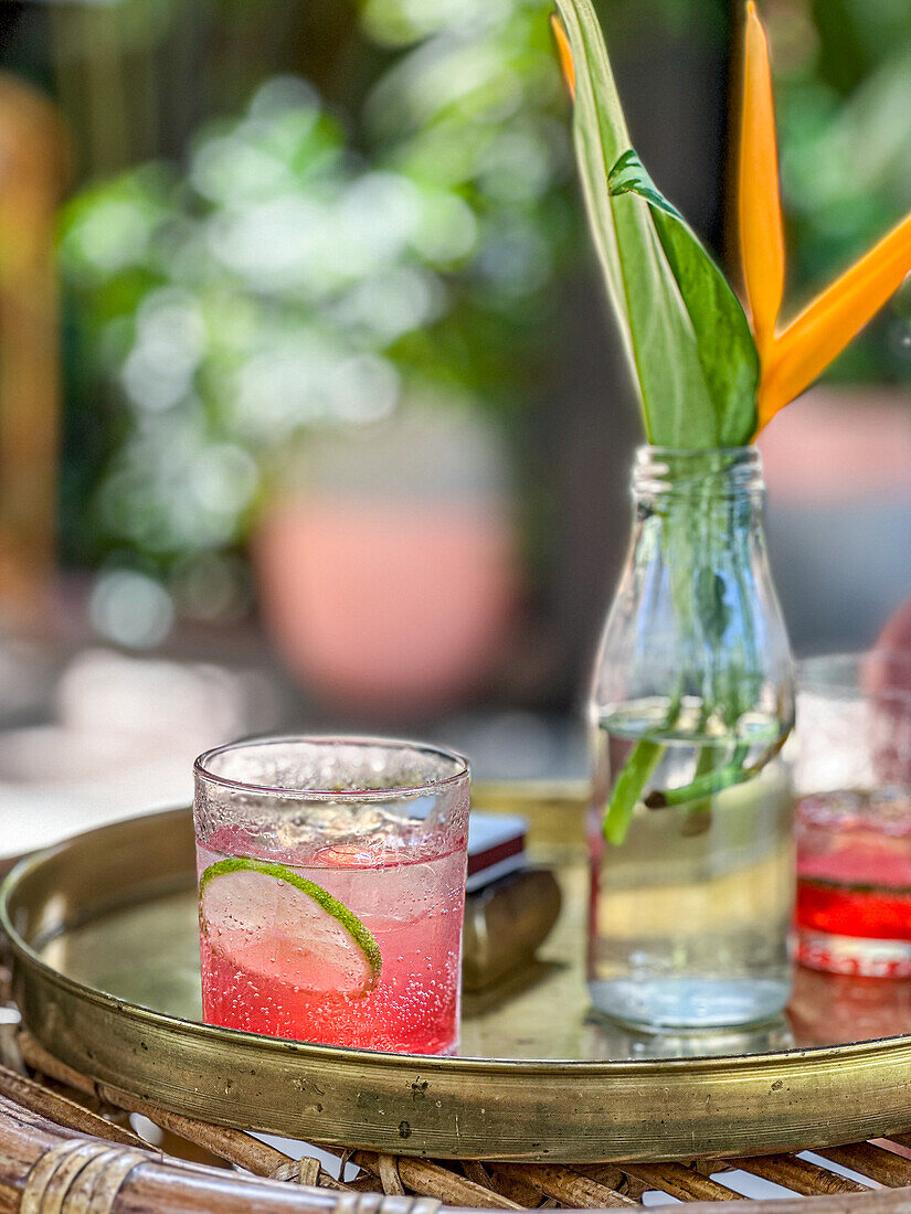 Granatapfel-Cocktail mit Limettenscheibe auf Tablett