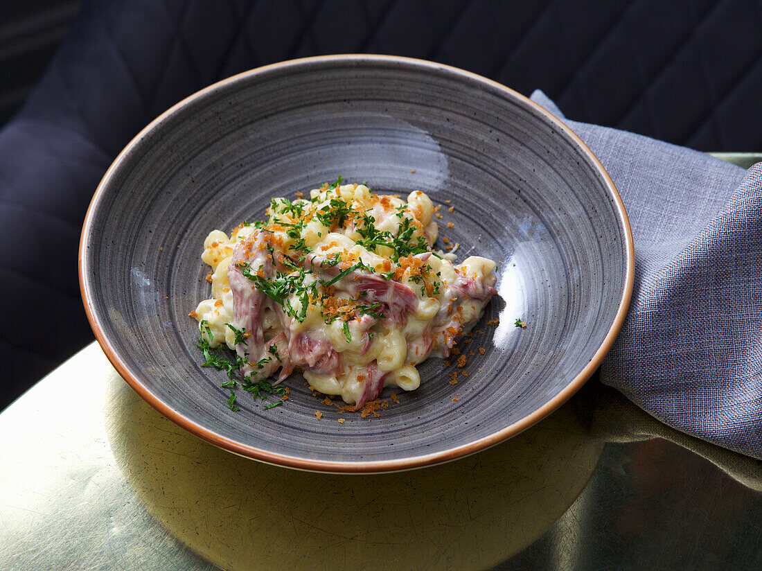 Pork knuckle baked with noodles and cheese