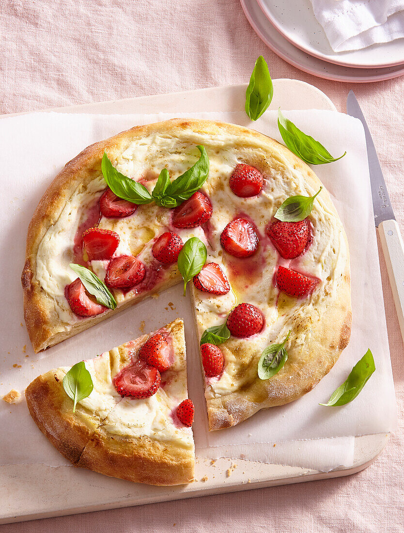Süße Pizza mit Erdbeeren und Basilikum