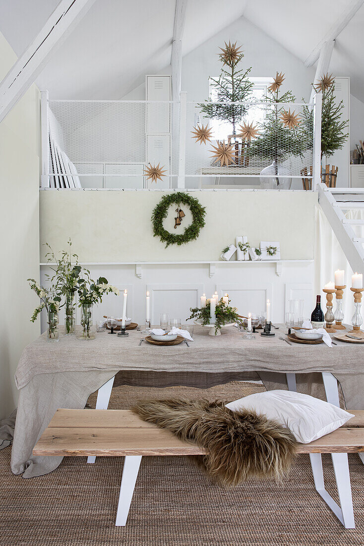 Dining table set for Christmas with lots of candles and Christmas tree decorations