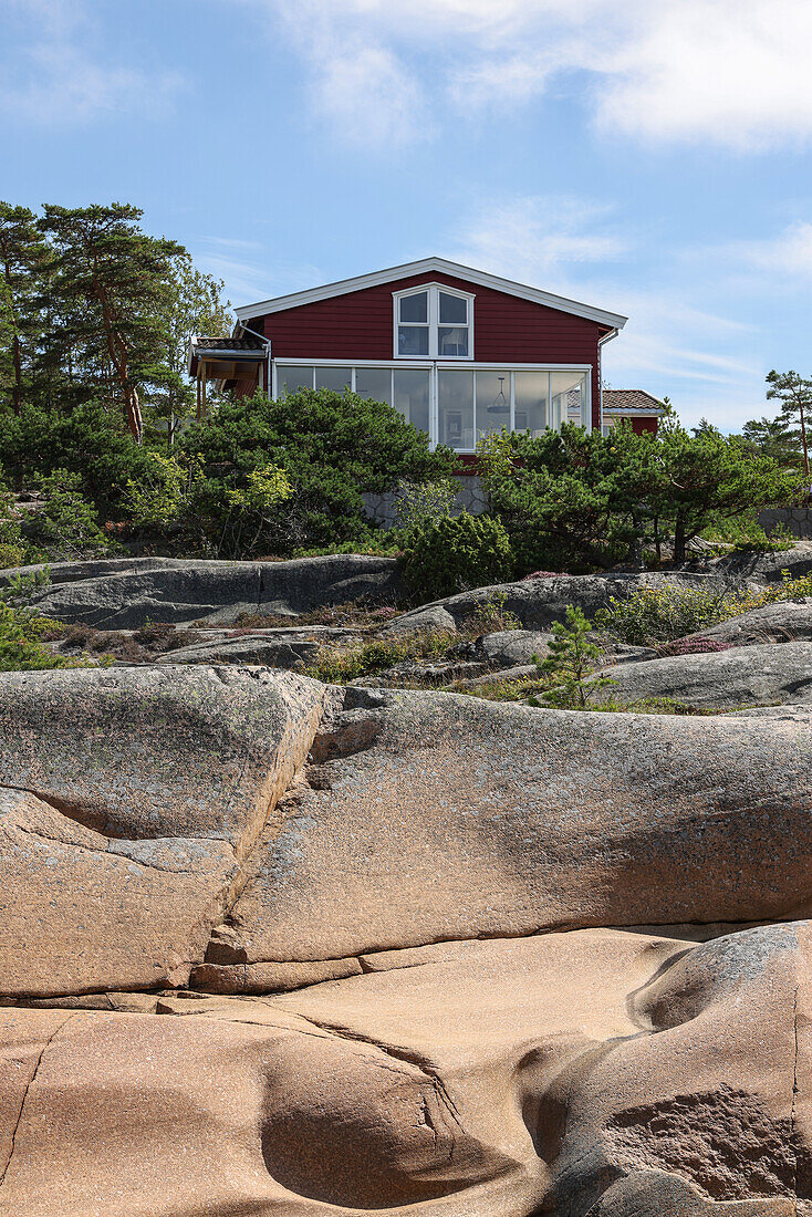 Wooden house with large windows in coastal landscape