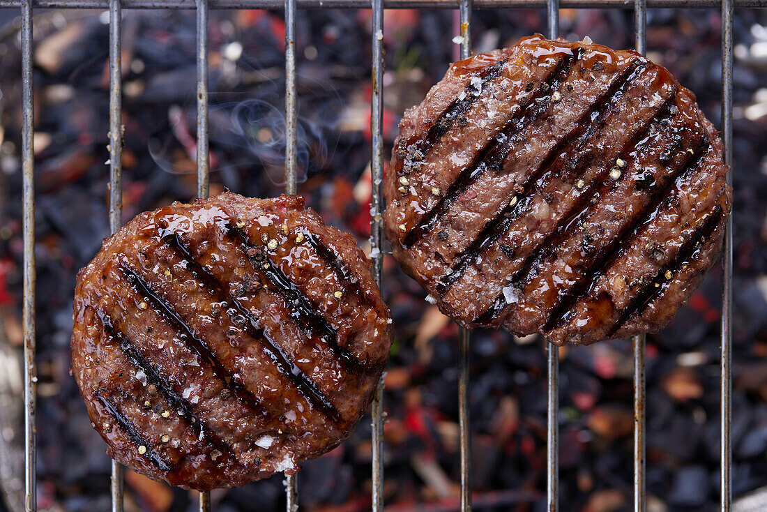 Grilled burger patties on a grill rack