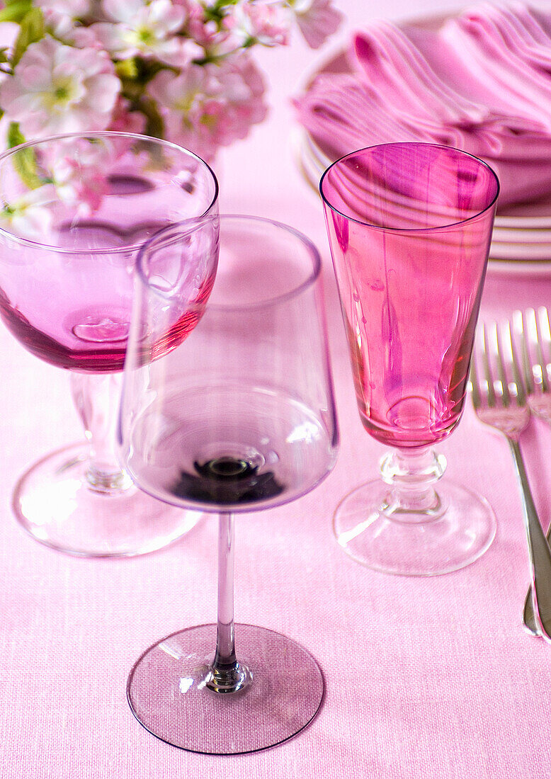 Rosa Weingläser auf einem gedeckten Tisch