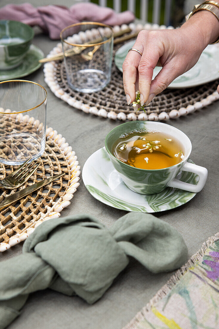 Tee mit Fliederblüten in eleganter Tasse