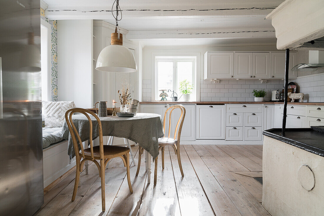 Bright eat-in kitchen with round table, chairs and built-in bench