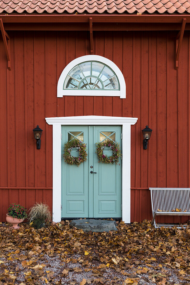 Red-brown wooden house with green double door