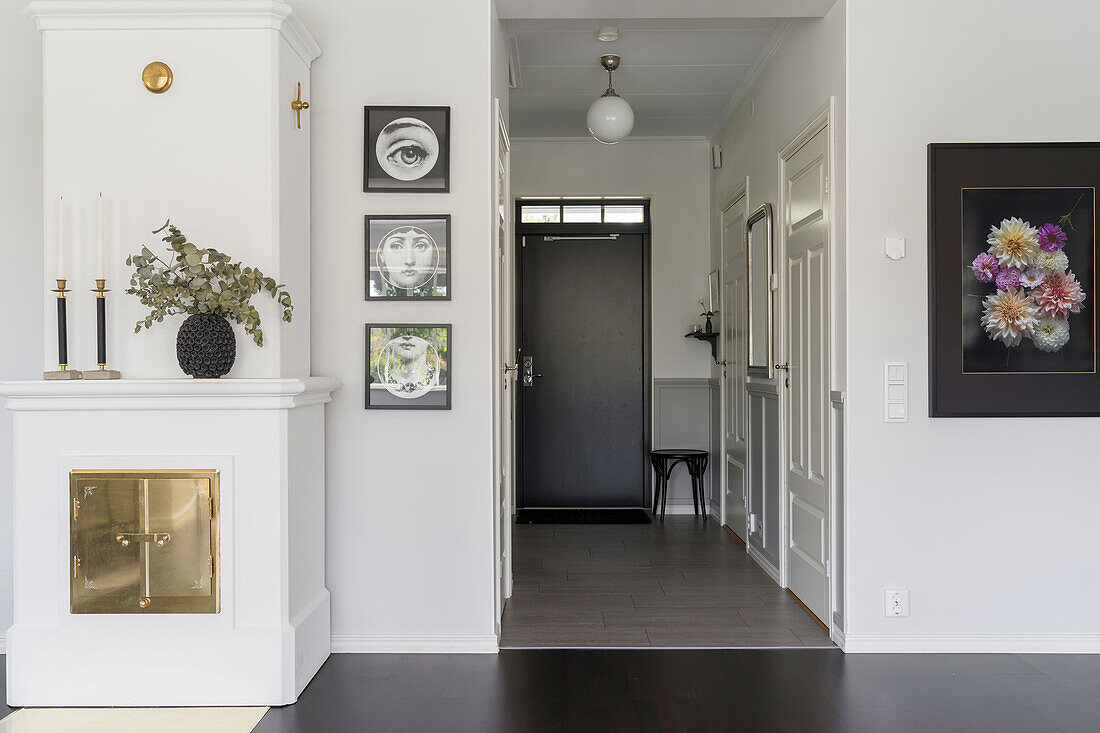 White tiled stove and pictures on the wall next to the hallway