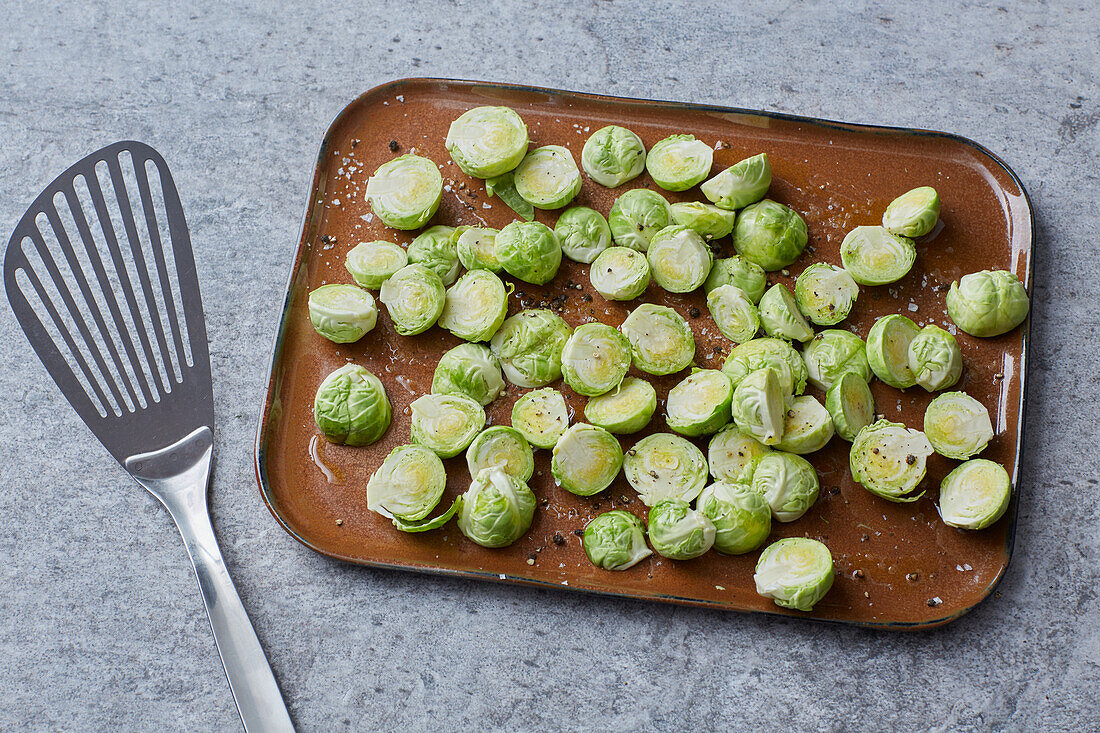 Rosenkohl mit Öl und Gewürzen für den Ofen vorbereiten