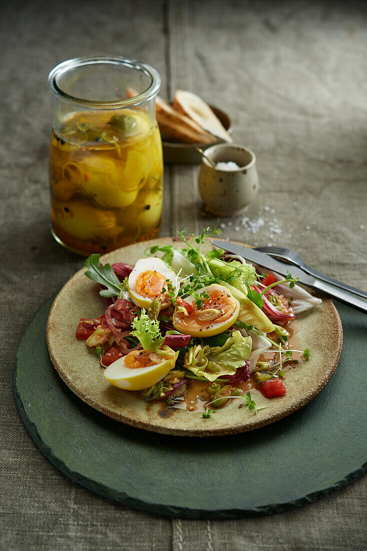 Halved oiled eggs from turmeric-soy spice brine served on greens