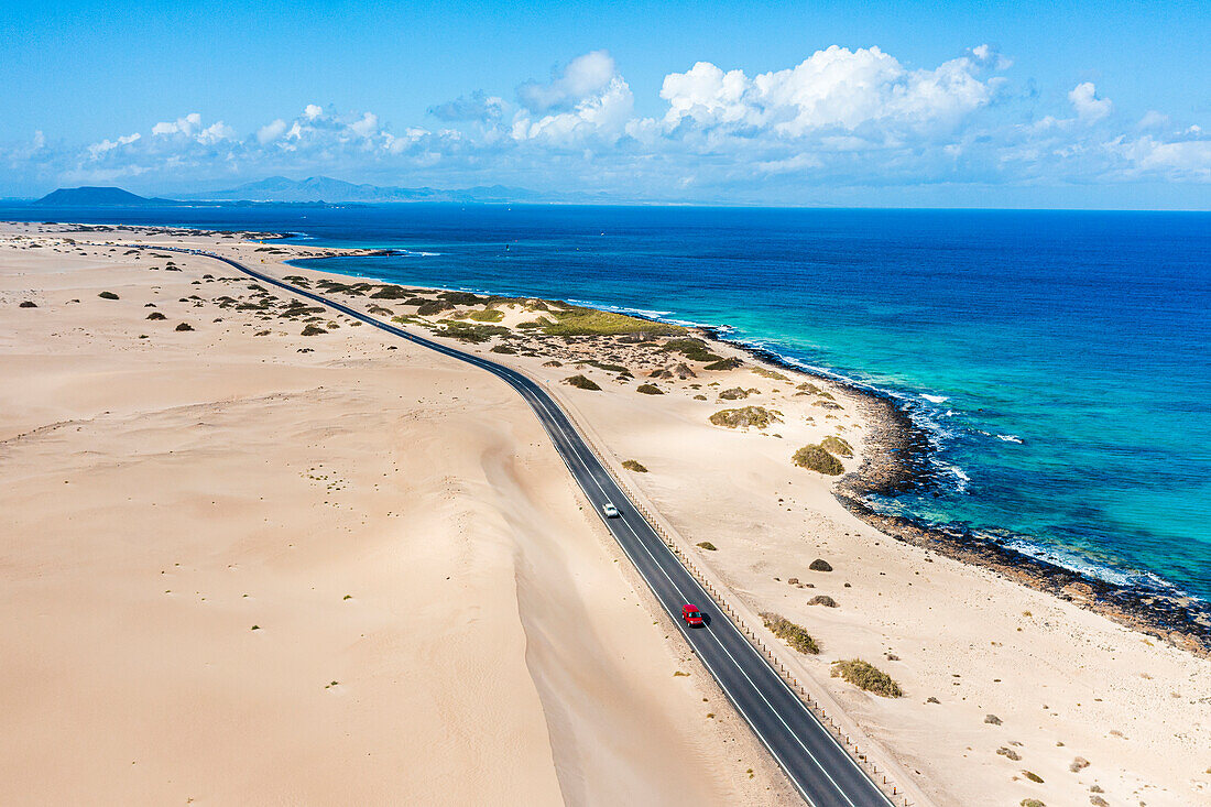 Auto auf der Straße zwischen Sanddünen und Meer, Luftaufnahme, Corralejo Natural Park, Fuerteventura, Kanarische Inseln, Spanien, Atlantik, Europa