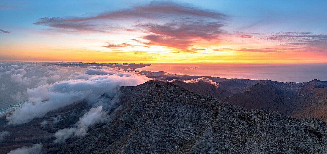 Brennender Himmel in der Morgendämmerung über dem Gipfel des Pico de la Zarza in einem Wolkenmeer, Jandia, Fuerteventura, Kanarische Inseln, Spanien, Atlantik, Europa