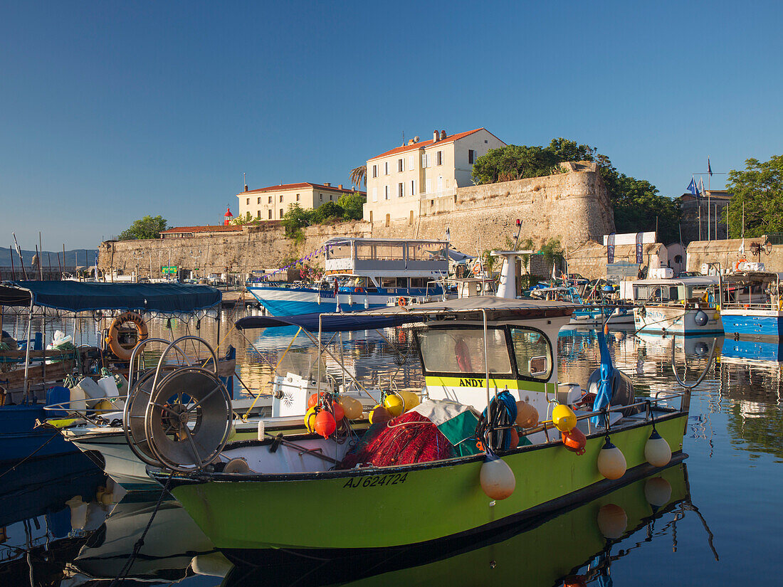 Blick über den beschaulichen Hafen auf die Zitadelle, Sonnenaufgang, typisches Fischerboot im Vordergrund, Ajaccio, Corse-du-Sud, Korsika, Frankreich, Mittelmeer, Europa